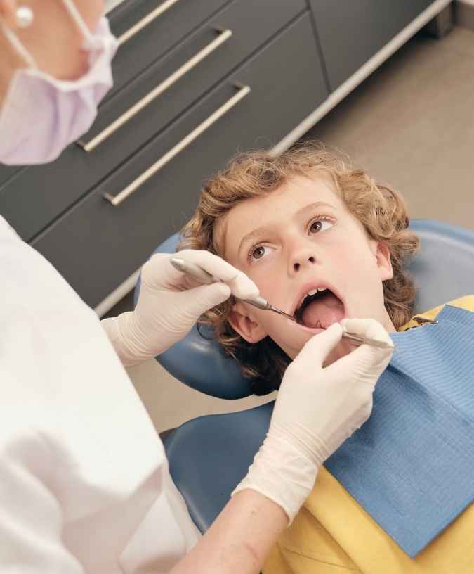 Dentist examining a child after a dental emergency